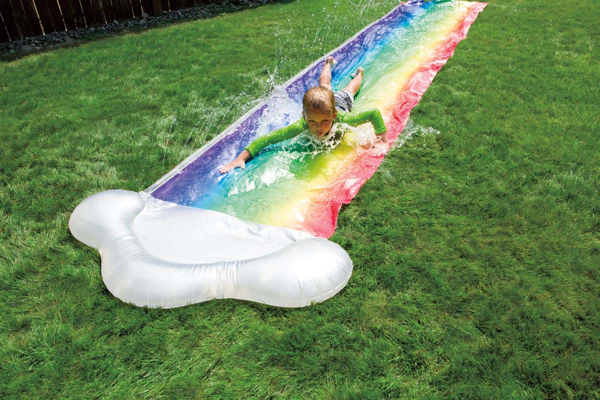 Boy sliding on Dash N Splash Rainbow Slide