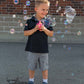 Young boy blowing bubbles outside with Turbo Bubble Blower.
